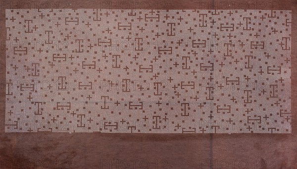 A katagami dyeing stencil cut into a pattern composed of small crosses, squares, and lines against a dense grid. Pattern: scattered on a fine grid are small squares, a + sign, and a figure resembling a mirror T. 19th/20th century Meiji period, 1868–1912. Japan. Stencil ise-katagami. Height 43.0 cm; width 25.3 cm., A rectangular sheet with a textured background in shades of brown fills the image, featuring a large lighter rectangular area near the top made up of a dense grid of small pale dots that form a repeating geometric pattern with gaps and blocky shapes; the lower portion shows darker brown with subtle variations in tone and soft stains, and there are small pale specks and a vertical darker streak near the lower center.