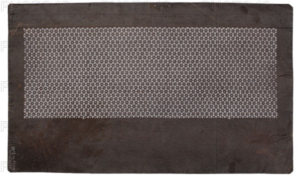 Katagami dyeing stencil; geometric komon pattern; maker, stencil; Japanese; Meiji period 19th/20th century, 1868–1912; height 40.6 cm, width 24.2 cm., A rectangular dark brown sheet with a large central rectangular area filled with a tight repeating pattern of small white shapes; the patterned area contrasts with the surrounding plain dark brown margins that show subtle creases, uneven edges, and a few lighter brown spots and scuffs; the overall colors visible are dark brown, lighter brown, and white.