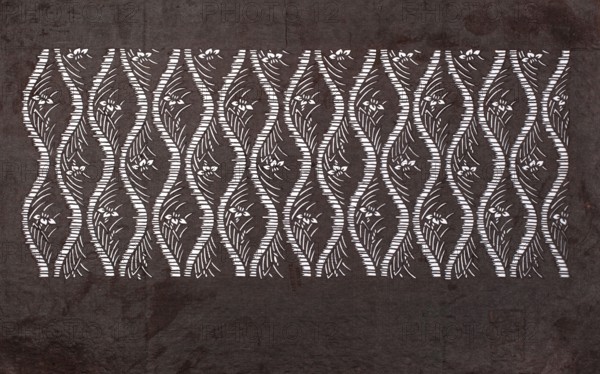 Katagami dyeing stencil; tatewaku wavy clouds pattern with tiny flowers and leaves, geometric and plant patterns, katagami, stencils, Japanese art, Japanese culture, 19th/20th century Meiji period 1868–1912, Japan, stencil, height 40.3 cm, width 24.3 cm, A patterned rectangular panel occupies the center of the image, featuring a repeating wavy lattice of light shapes against a darker background; within each wavy column are stylized floral and leaf motifs. The outer area around the panel shows a textured surface with uneven shading. Visible colors include dark brown, lighter brown, and white, with the white forming the repeating decorative shapes and the browns making up the surrounding textured field.