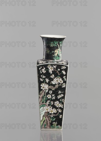Pair of vases, Chinese, 18th century, colored porcelain famille noire, decorated with birds, plums and floral motifs; vessel, height 22.5 cm., A tall, narrow vase with a flared rim and a square shoulder is shown against a plain gray background; the vase has a predominantly black surface decorated with floral and branch motifs in white, green, and pale pink, with brown tones for tree trunks and some lighter accents on the rim and interior, and a glossy finish that produces subtle reflections.