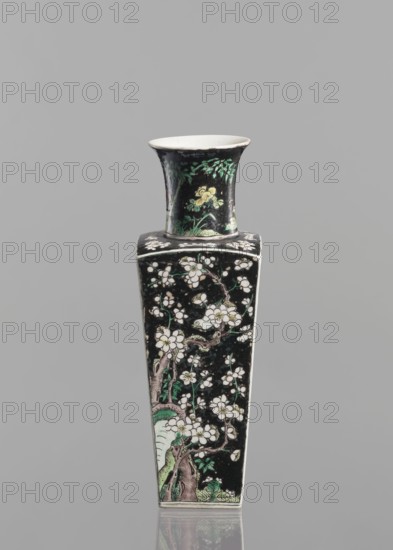 Pair of vases, Chinese, ceramics, colored porcelain famille noire, decorated with birds, plums, and floral motifs; 18th century China; vessel; height 22.5 cm; ., A tall, narrow ceramic vase with a flared rim and a square, tapered body sits against a plain gray background; the vase has a predominantly black surface decorated with floral and branch motifs in white, green, yellow, and pale pink, with green leaves and pale blossoms climbing the sides and a few yellow flowers near the neck, and the interior of the rim appears white.