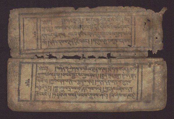 Buddhist text - Commentary on the praise of the names of Manjushri by Ga Rabjampa Kunga Yeshe Tib. 'phags pa 'jam dpal gyi mtshan yang dag par brjod pa zhugs so, unknown creator author, Buddhist art, Tibetan culture, graphic prints, Book in Tibetan pecha style, xylographic print in student script dbu can. 26 folios, recto page numbering, first verso, 2 pages missing. Buddhist commentary on the prayer of praise in honor of the names of the bodhisattva Manjushri Tib. 'jam dpal dbyang by Ga Rabjampa Kunga Yeshe Tib. sga rab 'byams pa kun dga' ye shes. The original text comes from the 15th century, 19th century, Tibet, graphics, width 24.6 cm, height 8.0 cm, An aged, rectangular double-leaf object lies against a dark background, showing two horizontal panels with framed areas and dense linear markings; the material appears worn and torn at the edges with several holes and irregular rips along the middle seam. The surface colors include brown, tan, beige, and darker brown or black lines and...