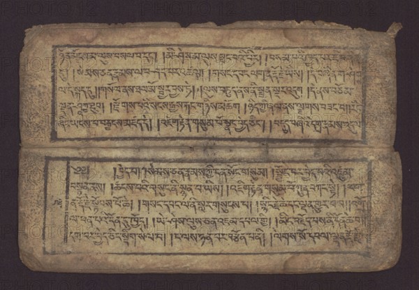 Buddhist text - Commentary on the praise of the names of Manjushri by Ga Rabjampa Kunga Yeshe Tib. 'phags pa 'jam dpal gyi mtshan yang dag par brjod pa zhugs so, unknown creator role, author. Buddhist art, Tibetan, graphic prints. Book in Tibetan pecha style, xylographic print in student script dbu can. 26 folios, recto page numbering, first verso, 2 pages missing. Buddhist commentary on the prayer of praise in honor of the names of the bodhisattva Manjushri Tib. 'jam dpal dbyang by Ga Rabjampa Kunga Yeshe Tib. sga rab 'byams pa kun dga' ye shes. Original text from the 15th century; this copy 19th century, Tibet. Graphics. Width 24.6 cm, height 8.0 cm., An open, aged rectangular manuscript with two horizontal panels separated by a fold, showing a worn beige paper surface framed by thin dark borders and filled with dense dark ink markings; the paper has uneven edges, rounded corners, and visible creases and stains, with areas of darker brown discoloration and spotting; the ink appears b...