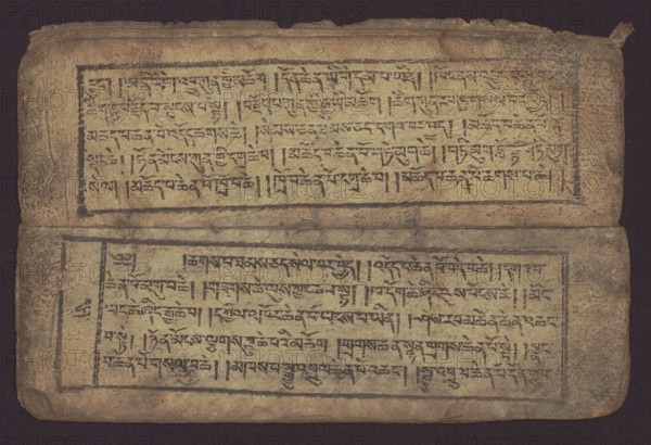 Buddhist text - Commentary on the praise of the names of Manjushri by Ga Rabjampa Kunga Yeshe Tib. 'phags pa 'jam dpal gyi mtshan yang dag par brjod pa zhugs so, noted. Buddhist art, Tibetan, graphic prints, book in Tibetan pecha style, xylographic print in student script dbu can. 26 folios, recto page numbering, first verso, 2 pages missing. Buddhist commentary on the prayer of praise in honor of the names of the bodhisattva Manjushri Tib. 'jam dpal dbyang by Ga Rabjampa Kunga Yeshe Tib. sga rab 'byams pa kun dga' ye shes. Original text from the 15th century; this copy 19th century, Tibet. Graphics; width 24.6 cm, height 8.0 cm., A worn rectangular object with a textured surface lies against a dark background, showing a muted palette of beige, tan, brown, black, and faded gray. The object appears to be made of layered material with rounded corners and slightly frayed edges, divided visually into two horizontal panels separated by a crease. Each panel is framed by dark rectangular bord...