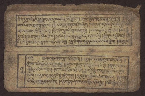 Buddhist text - Commentary on the praise of the names of Manjushri by Ga Rabjampa Kunga Yeshe Tib. 'phags pa 'jam dpal gyi mtshan yang dag par brjod pa zhugs so, Buddhist art, Tibetan culture, graphic prints, Book in Tibetan pecha style, xylographic print in student script dbu can. 26 folios, recto page numbering, first verso, 2 pages missing. Buddhist commentary on the prayer of praise in honor of the names of the bodhisattva Manjushri Tib. 'jam dpal dbyang by Ga Rabjampa Kunga Yeshe Tib. sga rab 'byams pa kun dga' ye shes. The original text comes from the 15th century; 19th century, Tibet. Graphics, width 24.6 cm, height 8.0 cm, An open rectangular manuscript page laid flat, showing two horizontal blocks of script separated by a narrow blank band, each block framed by a dark rectangular border; the page surface is textured and aged with a patina of yellowed beige and tan, with areas of darker brown and muted ochre, and the inked script appears in a deep black that has slightly faded ...