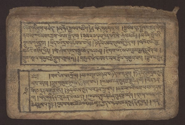 Buddhist text - Commentary on the praise of the names of Manjushri by Ga Rabjampa Kunga Yeshe Tib. 'phags pa 'jam dpal gyi mtshan yang dag par brjod pa zhugs so, unknown creator role, noted, Buddhist art, Tibetan, graphic prints, Book in Tibetan pecha style, xylographic print in student script dbu can. 26 folios, recto page numbering, first verso, 2 pages missing. Buddhist commentary on the prayer of praise in honor of the names of the bodhisattva Manjushri Tib. 'jam dpal dbyang by Ga Rabjampa Kunga Yeshe Tib. sga rab 'byams pa kun dga' ye shes. Original text from the 15th century; this copy 19th century, Tibet. Graphics, width 24.6 cm, height 8.0 cm., An aged rectangular manuscript page lies flat against a dark background, showing a worn beige surface with darker brown edges and a few rough, frayed spots; the page is divided into two horizontal panels outlined with thin dark borders, each panel filled with dense dark markings arranged in horizontal rows; the upper panel has a slightly...