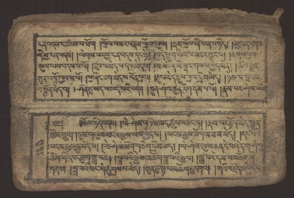 Buddhist text - Commentary on the praise of the names of Manjushri by Ga Rabjampa Kunga Yeshe Tib. 'phags pa 'jam dpal gyi mtshan yang dag par brjod pa zhugs so, unknown creator author, Buddhist art, Tibetan, graphic prints, Book in Tibetan pecha style, xylographic print in student script dbu can. 26 folios, recto page numbering, first verso, 2 pages missing. Buddhist commentary on the prayer of praise in honor of the names of the bodhisattva Manjushri Tib. 'jam dpal dbyang by Ga Rabjampa Kunga Yeshe Tib. sga rab 'byams pa kun dga' ye shes. The original text comes from the 15th century; this object is 19th century, Tibet. Graphics, width 24.6 cm, height 8.0 cm., An open, aged manuscript page fills the image, showing two rectangular blocks of densely written script separated by a horizontal division. The page surface is a weathered beige with areas of darker brown aging and edge wear, and the ink for the script appears dark brown to black. A few faint smudges and spots are visible on th...