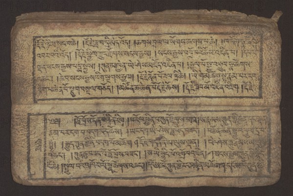 Buddhist text - Commentary on the praise of the names of Manjushri by Ga Rabjampa Kunga Yeshe Tib. 'phags pa 'jam dpal gyi mtshan yang dag par brjod pa zhugs so, unknown creator/graphic artist, Buddhist art, Tibetan culture, graphic prints, Book in Tibetan pecha style, xylographic print in student script dbu can. 26 folios, recto page numbering, first verso, 2 pages missing. Buddhist commentary on the prayer of praise in honor of the names of the bodhisattva Manjushri Tib. 'jam dpal dbyang by Ga Rabjampa Kunga Yeshe Tib. sga rab 'byams pa kun dga' ye shes. Original text from the 15th century; this object 19th century, Tibet. Graphics, width 24.6 cm, height 8.0 cm, A worn rectangular manuscript page lies flat against a dark background, showing two horizontal panels separated by a fold. The page surface is an aged beige with mottled brown and tan staining, and the edges are darker and frayed. Each panel is framed by a thin darker border and filled with dense rows of short vertical and ho...