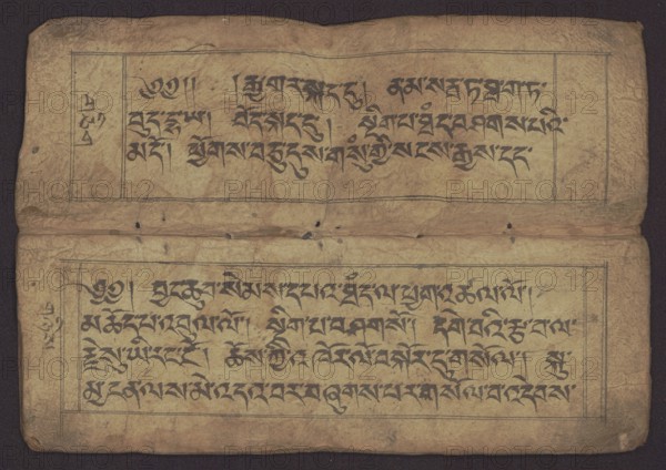 Buddhist Manuscript - Penitential Text Tib. sDig bshags gser gyi zhes bya ba bzhugs+o, unknown author/scribe, Tibetan Buddhist art, Himalayan culture, Book in Tibetan pecha style, manuscript in student's script. Leaf numbering 2-22 verso, first recto, last two unnumbered. Handwritten notes folio 24 recto and verso. 19th century, Tibet; manuscript, width 24.0 cm, height 8.1 cm, A worn, rectangular sheet with a tan to light brown paper surface shows a pair of horizontal panels containing dense dark black brushstroked script; the panels are outlined with thin black rectangular borders and separated by a crease where the paper is folded. The paper has visible age-related discoloration in shades of tan, brown, and faint yellow, with small dark spots and tiny holes scattered across the surface. There are marginal ink marks and a narrow vertical column at the left side of each panel with additional dark strokes. The edges of the sheet are irregular and slightly frayed, and the background behi...