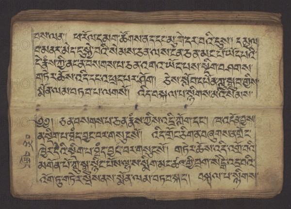 Buddhist Manuscript - Penitential Text Tib. sDig bshags gser gyi zhes bya ba bzhugs+o, unknown creator scribe-copyist, Tibetan Buddhist art, Himalayan culture, Book in Tibetan pecha style, manuscript in student's script. Leaf numbering 2-22 verso, first recto, last two unnumbered. Handwritten notes folio 24 recto and verso. 19th century, Tibet, manuscript, width 24.0 cm, height 8.1 cm, An aged rectangular page with a beige to yellowed background and darker browned edges lies flat, showing a textured surface and slightly wavy top and bottom borders; the page contains a group of dark black ink markings arranged in horizontal lines across the upper and lower halves, separated by a faint crease and a few darker spots along the middle; thin vertical ink rules frame the text blocks at the left and right margins; the ink varies slightly in intensity with some blotchy darker areas and small smudges; the page shows a few small holes or punctures near the center fold and subtle stains and discol...