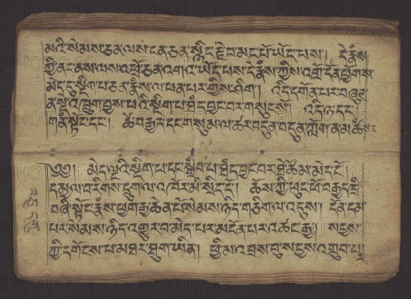 Buddhist Manuscript - Penitential Text Tib. sDig bshags gser gyi zhes bya ba bzhugs+o, unknown creator scribe-copyist, Tibetan Buddhist art, Himalayan culture, Book in Tibetan pecha style, manuscript in student's script. Leaf numbering 2-22 verso, first recto, last two unnumbered. Handwritten notes folio 24 recto and verso. 19th century, Tibet, manuscript, width 24.0 cm, height 8.1 cm, A worn, rectangular manuscript page lies flat against a dark background, showing an aged tan paper surface with visible creases and slight discoloration, darker along the edges and fold. The page contains a group of several lines of dense black calligraphic script arranged in two horizontal blocks separated by a horizontal crease, with margin lines framing the text in places. The paper shows small stains and spots in muted brown and gray, and the edges are slightly frayed and darker brown. The overall visible colors are tan, black, brown, gray, and a dark background bordering the page.