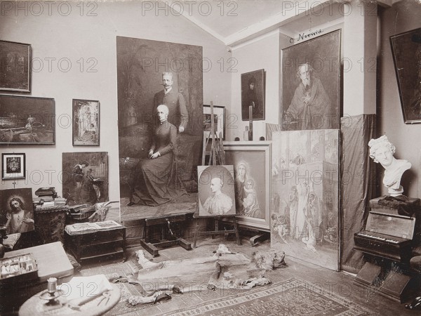 The Last Studio of Pantaleon Szyndler in Warsaw Painting studio of Pantaleon Szyndler 1846–1905 in Aleje Jerozolimskie in Warsaw, Bogacki, Stanislaw fl. ca 1890–ca 1935 photographer / author, painting, Polish painting, Szyndler, Pantaleon 1846–1905, interiors, Imperial Society for Rational Hunting, Warsaw Cyclists' Society 1886–, artists' studios, painters' studios, Szyndler, Pantaleon 1846–1905 - reproduction, photography, Norwid, Cyprian Kamil 1821–1883 - iconography, print glued across the entire surface onto cardboard, ca. 1902–1905, Warsaw, photography, nature photography, photographic print: height 17.4 cm, width 23.4 cm; cardboard: height 24.6 cm, width 34.9 cm; passe-partout: height 32.0 cm, width 43.0 cm, The sepia-toned image shows an interior room with a group of paintings leaning against walls and easels, including a large portrait of a seated woman with a standing man behind her, smaller portraits, and a tall canvas with multiple figures. A plaster bust rests on a small ta...