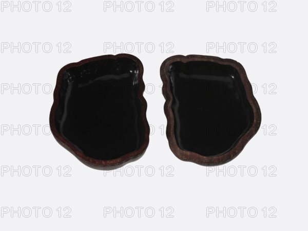 Box with a decorated jade plaque; maker, container/box; Qing style, 19th century, China; materials: jade plaque, gourd box; function: box; dimensions: height 4.8 cm, width 9.0 cm, depth 6.8 cm., A pair of irregularly shaped shallow dishes with glossy black interiors and dark brown edges, each dish showing a wavy, organic outline and a smooth reflective surface, set against a pale gray background.