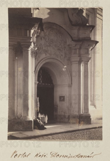 Dominican Church portal; photograph, Bulhak, Jan 1876–1950, Vilnius Lithuania, baroque style, Dominican Church of the Holy Spirit Vilnius, 1912; photographic print: height 15.5 cm, width 11.1 cm; album page: height 31.0 cm, width 23.5 cm, The image shows a stone building entrance with decorative architectural details, including an arched doorway framed by columns and ornate relief above the arch; a dark interior is visible through the doorway and a person wearing a dark garment is seated or crouched near the entrance; the scene includes a paved street in front and strong light creating highlights and shadows on the columns and facade; visible colors include shades of beige, cream, brown, gray, and black.