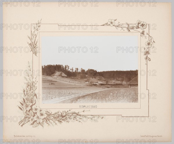 Soplicowo Farmstead; album of souvenir views of the Nowogródek and Slutsk poviats; collected by Teofil Eugeniusz Boretti. Photograph by Józef Mikolaj Boretti. Subject: rural farmsteads, Soplicowo Nowogródek poviat, Belarus; landscapes; Mickiewicz, Adam 1798–1855 referenced. Technique and materials: photographic print glued with entire surface on lithographed cardboard; photography from nature. Date: 1894. Place of creation: Minsk, Lithuania. Measurements: photographic print height 15.6 cm, width 22.7 cm; album page height 33.0 cm, width 39.8 cm., The image shows a vintage photograph of a rural landscape mounted on a decorative cream-colored mat with floral line drawings. The central photograph displays a countryside scene with gently sloping fields, a dirt track or path, and a group of thatched-roof buildings clustered near the middle ground, backed by a treeline of tall trees. A few animals appear in a field near the foreground. The mat features delicate floral and leafy border illust...