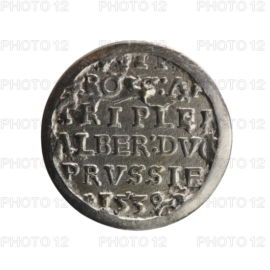 trojak, Vogelwaider Vogelwaid, Eustachius mintmaster/publisher, Decius, Jost Ludwik fl. 1528–1535 co-creator/mint manager. Albrecht Hohenzollern Prince of Prussia; 1490–1568 — iconography: male bust in armour, stars. Obv.: male bust in armour in profile turned to the right; short hair, beard with sideburns. Inscription around the rim: *ALBER DG MAR BRAN DVX PRVSS. Continuous border, floral motifs between the words. Rev.: inscription in six lines: -III*/-.ROSS:A.-/-TRIPLE.-/-ALBER:DVC-/-PRVSSIE-/*I539-. Date: 1539. Place: Ducal Prussia 1525–1701, Königsberg mint. Coin trojak: diameter 21.6 mm, weight 2.63 g, axis 30°., A round metallic object with a worn, textured surface shown against a white background; the object displays raised, carved shapes and irregular indentations across its face, with scratches and rough edges visible around its rim. The surface shows a mix of metallic gray and darker gray tones, with lighter highlights where the metal catches the light and some small areas of...