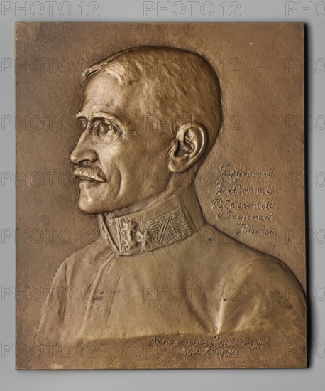 Zygmunt Zielinski; Chodzinski, Kazimierz Mieczyslaw 1861–1921 medalist/author. Obverse: male bust 3/4 turned left, short trimmed mustache, in uniform with sewn-on military insignia; right side inscription in 5 lines. Date: 1916. Place: Vienna, Poland. Material: plaque. Dimensions: 1140 mm × 167 mm., A bronze relief plaque shows the left-profile bust of a man with short hair and a moustache, wearing a high-collared garment with decorative patterning on the collar; the surface has a metallic bronze color with areas of darker and lighter bronze patination and a few small darker spots, set against a gray backdrop.