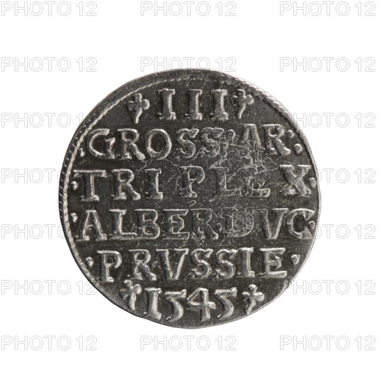 Trojak coin by Maciej Schilling, co-creator Jost Ludwik Decjusz fl. 1528–1535, 1545. Obverse: male bust in armour in profile facing right; short hair, long pointed beard with sideburns; rim inscription beginning with a trefoil: -ALBER DG MAR BRAN DVX PRVSS; pearl border and plant motifs between words. Reverse: six-line inscription in the pearl border: -III-/.GROSS:AR:/.TRIPLEX./.ALBER:DVC./.PRVSSIE./-I545-; denomination and date between trefoil marks. Ducal Prussia 1525–1701, Königsberg mint. Coin; diameter 21.2 mm, weight 2.70 g, axis 140°., A circular metallic coin with a worn, textured surface showing raised, carved designs and markings across its face; the coin appears mostly silver-gray with darker gray recesses and subtle areas of lighter reflective silver on the raised portions; the edge shows slight irregularities and a narrow rim; overall the coin surface displays scratches, small pits, and scuffs with a patina that creates contrasting light and dark gray tones.