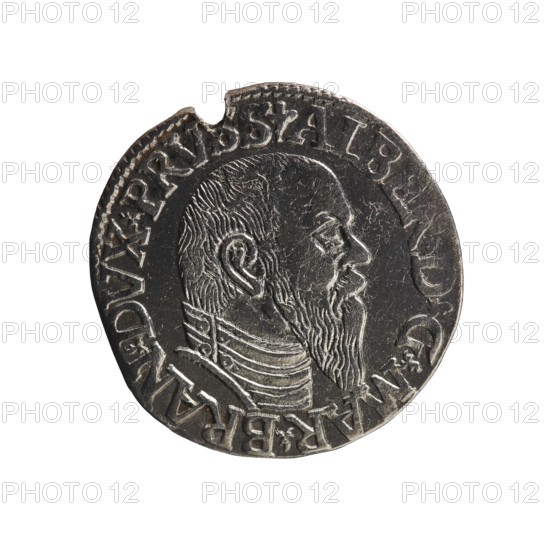 Trojak, Schilling, Maciej mintmaster co-creator. Obverse: male bust in armour in profile facing right; short hair, long pointed beard with sideburns. In the rim an inscription beginning with a trefoil -ALBER DG MAR BRAN DVX PRVSS; pearl border, plant motifs between the words. Reverse: in the pearl border an inscription in six lines -III-/.GROSS:AR:/.TRIPLEX./.ALBER:DVC./.PRVSSIE./-I546-; denomination and date between trefoil marks. 1546. Ducal Prussia 1525–1701, Königsberg mint. Coin trojak/schilling; diameter 21.1 mm; weight 2.54 g; axis 220°., A round metallic coin with a detailed profile of a bearded man's head facing right, showing textured hair, ear, and a layered collar or garment at the neck; the coin surface is worn with scratches and small dents, and there is a notch at the rim near the top; visible colors include silver, dark gray, and black tones across the coin, set against a white background.
