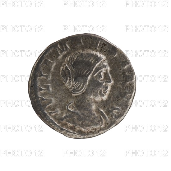 Denarius, Elagabalus 204–222; Roman emperor 218–222. Obv.: IVLIA MAESA AVG — Draped bust of Julia Maesa facing right, pearl rim. Rev.: PVDICITIA — Veiled Pudicitia seated on a throne facing left, raising the hem of her veil with her right hand and holding a scepter in her left, pearl rim. 218–223. Roman Empire 27 BC–476. Rome. Coin; diameter 19.5 mm; weight 3.30 g., A circular metallic object with a worn, uneven surface showing a raised profile of a person facing right; the person has stylized hair pulled back and subtle facial features, and the surrounding field has irregular raised borders and textured wear. The object is primarily gray and silver with darker gray and brownish tarnish spots, set against a plain white background.