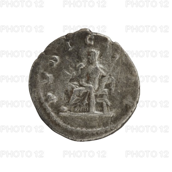 Denarius of Julia Maesa ca. 160–224; Augusta 218–224. Obverse: Draped bust of Julia Maesa facing right, pearl border; inscription IVLIA MAESA AVG. Reverse: Veiled Pudicitia seated on a throne facing left, raising the hem of her veil with her right hand and holding a scepter in her left; pearl border; inscription PVDICITIA. Roman Empire, struck 218–223 in Rome. Coin; diameter ~18.5–19.0 mm; weight 3.05 g., A circular metal coin with a worn, uneven surface in gray and dark gray tones showing a raised central design of a seated human figure on a raised platform, with the figure’s outline and surrounding shapes appearing weathered and indistinct against the coin’s textured background, and a lighter rim around the edge where the metal shows subtle variations in gray and silvery highlights.