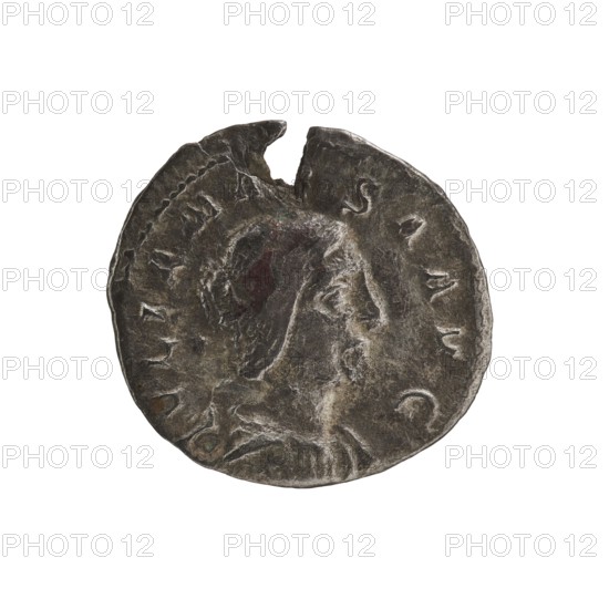 Denarius, Elagabalus 204–222; Roman emperor 218–222. Obverse: IVLIAMAE SAAVG — Draped bust of Julia Maesa facing right, pearl border. Reverse: PVDICITIA — Veiled Pudicitia sits on a throne facing left, raising the hem of her veil with her right hand, holding a scepter in her left, pearl border. Date: 218–223. Roman Empire. Mint: Rome. Coin. Diameter: 17.5–18.5 mm. Weight: 2.15 g., A worn round metallic object with an irregular edge and a small chip at the top, showing a raised profile of a person's head in relief facing right; the surface has textured wear, scratches, and small dents, with darker and lighter areas creating mottled tones of gray, silver, and hints of brown and green patina.