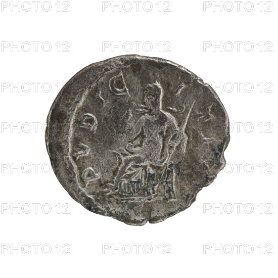 Denarius of Julia Maesa ca. 160–224; Augusta 218–224. Obverse: Draped bust of Julia Maesa facing right, pearl border; inscription IVLIA MAESA AVG. Reverse: Veiled Pudicitia seated on a throne facing left, raising the hem of her veil with her right hand and holding a scepter in her left; inscription PVDICITIA. Roman Empire, struck 218–223. Coin; diameter ~18.0–19.5 mm, weight 2.27 g., A worn circular metal object with an uneven edge shown against a white background, displaying a raised, faintly detailed relief of a seated human figure and surrounding decorative marks; the surface shows varied textures with scratches, indents, and areas of wear, and the visible colors include shades of gray, dark gray, and small touches of greenish-blue.