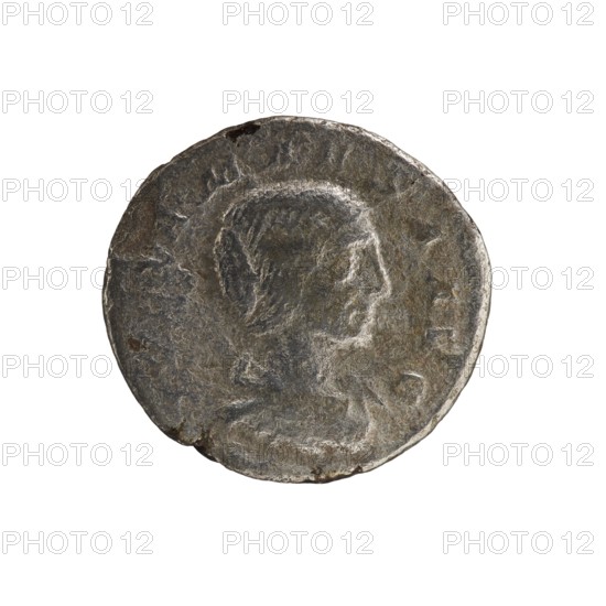 Denarius, Elagabalus Roman emperor 218–222. Obverse: IVLIA MAESA AVG — Draped bust of Julia Maesa facing right, pearl border. Reverse: PVDICITIA — Veiled Pudicitia seated on a throne facing left, raising the hem of her veil with her right hand and holding a scepter in her left, pearl border. Date: 218–223. Coin; dia. 17.5–18.5 mm, weight 2.60 g., A round, weathered metal coin with a worn raised profile of a person's head facing right, showing hair and facial contours; the surface is uneven with scratches and small pits, and the rim is irregular and slightly chipped in places. The visible colors are dark gray, silver, and hints of brown.