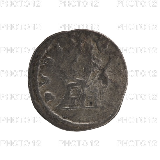 Denarius of Elagabalus reign 218–222. Obverse: IVLIA MAESA AVG — Draped bust of Julia Maesa facing right, pearl border. Reverse: PVDICITIA — Veiled Pudicitia seated on a throne facing left, raising the hem of her veil with her right hand and holding a scepter in her left, pearl border. Date: 218–223. Rome; Roman Empire. Coin; diameter 19.0 mm; weight 2.05 g., A round, worn coin with a rough, uneven surface and a dark gray to brown patina, showing a faint raised profile of a head on one side and an indistinct raised shape near the center; the coin edge is irregular and the overall appearance is aged and metallic with areas of lighter gray highlights and darker brown-gray shadows.