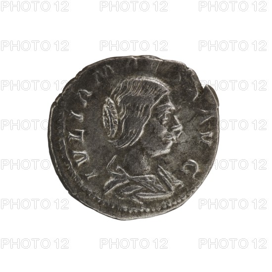 Denarius, Elagabalus 204–222; Roman emperor 218–222. Obv.: IVLIA MAESA AVG — Draped bust of Julia Maesa facing right, pearl rim. Rev.: SAECVLI FELICITAS — Felicitas stands facing left; in her right hand she holds a patera above a burning altar, in her left hand a long caduceus; in the right field a star, pearl rim. Date: 218–223. Place of origin: Rome. Material/format: coin. Diameter: 18.0–18.5 mm. Weight: 3.40 g., A round metallic object with a worn, dark gray surface showing a raised profile of a person facing right; the person has detailed hair and a small bun or knot at the back of the head and wears a draped garment at the shoulder. The object has an irregular rim with a few notches and areas of lighter gray where the metal catches the light, and the background is plain white.