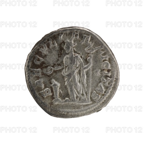 Denarius, Elagabalus 204–222; Roman emperor 218–222. Obverse: IVLIA MAESA AVG — Draped bust of Julia Maesa facing right, pearl border. Reverse: SAECVLI FELICITAS — Felicitas standing left; in her right hand a patera raised above a burning altar, in her left a long caduceus; star in right field, pearl border. Rome mint, 218–223. Coin; diameter c. 18.5–19.0 mm, weight 2.95 g., A round metallic coin with a worn surface in shades of silver and gray, showing an engraved standing figure draped in robes at the center. The figure appears to hold an object in one hand while a staff-like object rests beside them. A small kneeling figure is depicted near the larger figure's feet. The coin edge is irregular and the surface has darker gray patches and lighter highlights from wear.