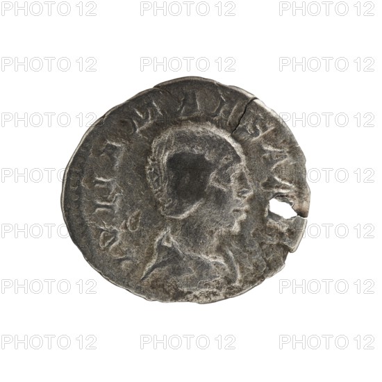Denarius, Elagabalus 204–222; Roman emperor 218–222. Obverse: IVLIA MAESA AVG — Draped bust of Julia Maesa facing right, pearl border. Reverse: SAECVLI FELICITAS — Felicitas standing left; right hand holds a patera above a burning altar, left hand holds a long caduceus, star in right field, pearl border. Rome, c. 218–223. Coin; diameter 17.5–19.0 mm; weight 2.40 g., A worn, round metallic object with a rough tarnished surface in shades of gray, silver, and dark charcoal, showing the raised profile of a person facing right; the profile has textured hair and a visible neck and shoulder. The edge of the object is irregular with a small missing section near the right side, and there are faint raised elements and curved ridges around the perimeter. The background is plain white.