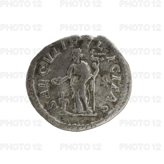 Denarius, Elagabalus 204–222; Roman emperor 218–222. Obv.: IVLIA MAESA AVG — Draped bust of Julia Maesa facing right, pearl border. Rev.: SAECVLI FELICITAS — Felicitas standing left; in her right hand she holds a patera above a burning altar, in her left hand a long caduceus; star in the right field, pearl border. Rome, 218–223. Coin; diameter 17.0–19.0 mm; weight 2.52 g., A round metallic object with a worn, uneven edge showing a grey and silver patina, featuring a raised central relief of a standing human figure holding an object in one hand and a long staff in the other, with a smaller raised shape beside the figure and decorative raised border around the perimeter.