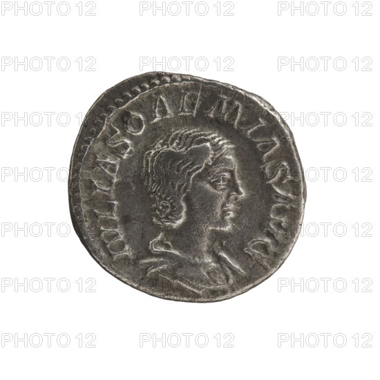 Denarius, Elagabalus 204–222; Roman emperor 218–222. Obverse: Draped bust of Julia Soaemias 180–222; Augusta 218–222 facing right, pearl border, inscription IVLIA SOAEMIA SAVG. Reverse: VENVS CAELESTIS; Venus standing left, holding an apple in her right hand and a scepter in her left, star in the left field, pearl rim. Rome mint, 218–222. Coin; diameter ~17.5–18.5 mm, weight 2.82 g., A circular metallic object with a worn surface showing a raised profile of a person's head in side view, with detailed wavy hair and facial features; the edge of the object has a raised border with a pattern of irregular raised shapes; the metal appears in shades of gray and silver with darker gray areas in recessed parts and lighter silver highlights on raised areas; the background is plain white.