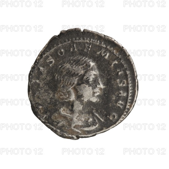 Denarius, Elagabalus 204–222; Roman emperor 218–222. Obverse: Draped bust of Julia Soaemias facing right, pearl border; inscription IVLIASOAEMIASAVG. Reverse: Venus seated on a throne facing left, holding an apple in her right hand and a scepter in her left; a child stands at her feet with outstretched arms, pearl border; inscription VENVSCAE L ESTIS. Issuer: Julia Soaemias 180–222. Rome, 218–222. Coin; diameter 19.0 mm, weight 3.20 g., A worn circular metallic coin with a profile of a person's head facing right in the center; the head shows short textured hair and facial features in low relief, and the surrounding area of the coin has raised edging and an irregular outer rim. The coin's surface shows dark gray, silver, and brown tones with areas of lighter silver highlights and darker shadowed patches, and the edge appears slightly chipped and uneven.