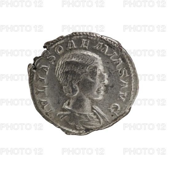 Denarius, Elagabalus 204–222; Roman emperor 218–222. Issuer: Julia Soaemias 180–222; Augusta 218–222. Obverse: IVLIASOAEMIASAVG — draped bust of Julia Soaemias facing right, pearl border. Reverse: VENVSCAELestis — Venus seated on a throne facing left, holding an apple in her right hand and a sceptre in her left; at her feet a child with outstretched arms, pearl border. Date: 218–222. Place of origin: Rome, Roman Empire. Coin; diameter 18.0–19.5 mm; weight 2.55 g., A circular metallic object with an uneven, worn edge showing a few small nicks and dents, featuring a raised profile of a person's head in relief facing right, with textured hair and a defined neck and shoulders; the surface shows varied shading and patina in tones of silver and gray with darker gray areas in the recesses, and lighter silvery highlights on the raised parts.
