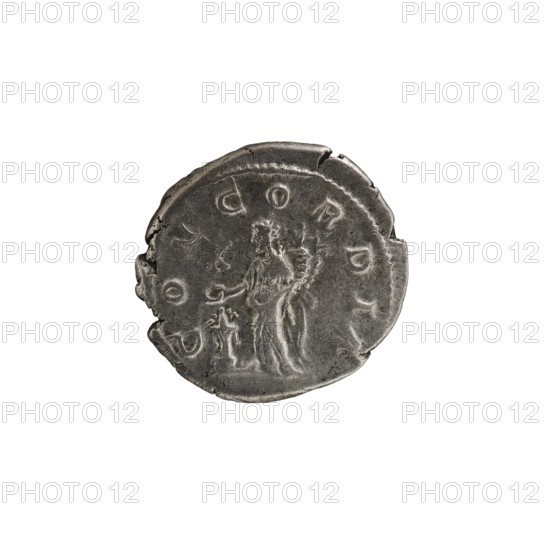 Denarius, Elagabalus Roman emperor 218–222. Issuer: Aquilia Severa fl. 220–222; Roman empress 221–222. Obverse: legend IVLIA AQVILIA SEVERA AVG; draped bust of Aquilia Severa facing right, pearl border. Reverse: legend CONCORDIA; Concordia standing left, holding a patera above a burning altar in her right hand and a double cornucopia in her left; star in right field, pearl rim. Roman Empire, Rome; 220. Coin denarius: diameter ~18.0–18.5 mm, weight 3.40 g., A round, worn metallic object with a rough edge and an uneven surface, showing a raised central relief of a standing human figure draped in flowing garments next to a smaller figure or object, with surrounding raised shapes and markings around the perimeter; the visible colors are shades of gray and dark silver on a white background.