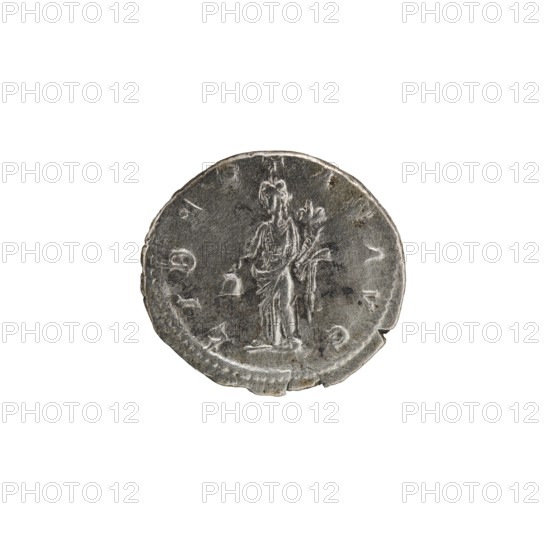 Denarius, Alexander Severus Roman emperor; 222–235 — Obv.: IMPCMAVRSEVALEXANDAVG. Bust of Alexander Severus wearing a laurel wreath, armor, and paludamentum facing right; pearl border. Rev.: LIBERTASAVG. Libertas standing, head left, holding a pileus in his right hand and a cornucopia in his left; pearl border. 222–228. Roman Empire. Rome. Coin; diameter ca. 17.5–19.0 mm; weight 2.90 g., A circular metallic object with a worn, uneven edge sits against a white background; the surface shows a raised, low-relief figure of a standing person draped in long robes, holding something long and branch-like in one hand and a small object in the other, with areas of darker tarnish and lighter silver-gray highlights across the patina.