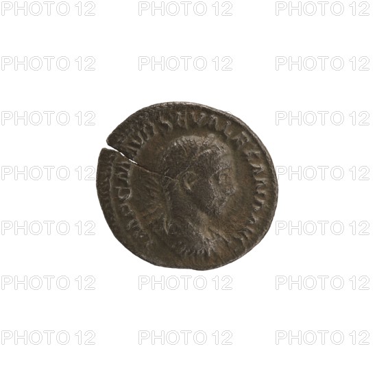 Denarius of Alexander Severus 208–235; Roman emperor 222–235. Obverse: Bust of Alexander Severus in laurel wreath, armor and paludamentum facing right; legend IMPCMAVRSEVALEXANDAVG. Reverse: Mars in military dress and helmet standing left, holding a branch in his right hand and leaning his left against a standing spear; legend MARTI PACIFERO. Rome, 222–228. Roman Empire; coin; diameter approx. 18.0–19.5 mm; weight 3.82 g., A single round coin with a dark brown and greenish patina sits against a white background, showing a worn profile of a person facing right with short hair and a beard; the coin edge is irregular with a visible crack and a chipped section, and there is a raised rim with decorative indentations around the portrait.