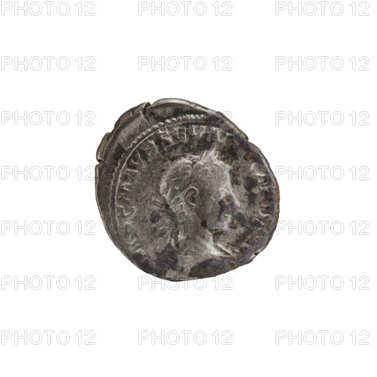 Denarius, Alexander Severus 208–235; Roman emperor 222–235. Obverse: Bust of Alexander Severus with laurel wreath and paludamentum facing right; legend IMPCMAVRSEVALEXANDAVG; pearl rim. Reverse: Mars in military dress and helmet standing left, holding a branch in his right hand and leaning his left against a standing spear; legend MARTIPACIFERO; pearl rim. Date: 222–228. Roman Empire. Mint: Rome. Coin; diameter 17.5–19.5 mm; weight 2.67 g., A worn circular metal coin with a raised profile of a person facing right, showing facial features and short hair, with visible rim and decorative beaded edge; the surface has areas of corrosion and pitting, with irregular dark brown and rusty patches and lighter silver-gray highlights, set against a plain white background.