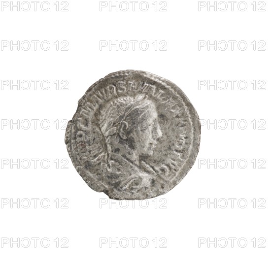 Denarius of Alexander Severus reigned 222–235. Obverse: Bust of Alexander Severus with laurel wreath and paludamentum facing right; legend IMPCMAVRSEVALEXANDAVG; pearl border. Reverse: Mars in military dress and helmet standing left, holding a branch in his right hand and leaning his left against a standing spear; legend PMTRPII COSPP; pearl border. Minted 223; Roman Empire. Coin: diameter ~19.0–19.5 mm, weight 2.55 g., A round metallic object with a worn, textured surface showing a raised profile of a person's head in side view, surrounded by a raised border and faint raised shapes along the edge; the object appears primarily silver-gray with darker gray areas and some subtle brownish discoloration.
