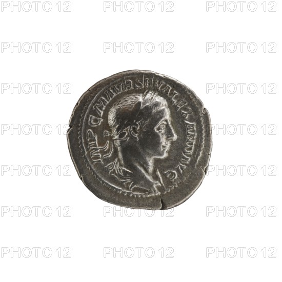 Denarius, Alexander Severus 208–235; Roman emperor 222–235. Obverse: Bust of Alexander Severus right with laurel wreath and paludamentum, pearl rim; inscription IMPCMAVRSEVALEXANDAVG. Reverse: Emperor in military dress standing straight, head turned left, holding a ball in his right hand and a spear in his left; inscription PMTRPIII COSPP. 224, Rome. Roman Empire 27 BC–476. Coin; diameter 20.5 mm; weight 3.25 g., A round metallic coin with a worn surface showing a raised profile of a person's head facing right; the head has short hair and a band or wreath around it, and the neck and shoulders are visible with some drapery. The coin's rim is irregular and slightly dented in places, and there is a raised border around the portrait. The color palette includes shades of silver, gray, and dark gray with subtle highlights and shadows.