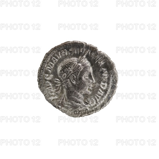 Denarius, personifications, Alexander Severus Roman emperor; 222–235 — iconography: Salus personification. Obverse: IMPCMAVRSEVALEXANDAVG — Bust of Alexander Severus right with laurel wreath and paludamentum, pearl rim. Reverse: PMTRPIII COS... — Salus seated facing left, holding a patera in her right hand feeding a snake coiled around an altar, lion resting its elbow on the backrest, pearl rim. Date: 224. Place of origin: Rome. Medium: silver coin. Diameter: 19.0–20.0 mm. Weight: 2.57 g., A circular metallic coin with a worn relief portrait in profile, showing a head facing right with short hair and a laurel or band around the head; the coin surface is textured and irregular at the edges, with raised decorative and patterned ridges around the perimeter. The visible colors are silver and gray tones with darker gray shadows and lighter silvery highlights.