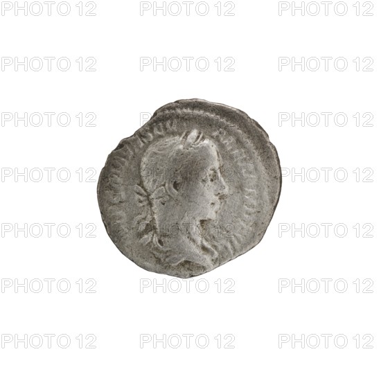 Denarius of Alexander Severus 208–235; Roman emperor 222–235. Obverse: Bust of Alexander Severus right, wearing a laurel wreath and paludamentum; inscription IMPCMAVRSEVALEXANDAVG. Reverse: Emperor in military dress standing turned left, holding a ball in his right hand and a spear with the point down in his left; inscription PMTRPIIII COSPP. Pearl rim. 225 CE. Rome, Roman Empire. Coin. Diameter ~16.5–19.5 mm; weight 2.15 g., A circular, worn metallic object with a raised profile of a person's head in relief facing right, showing hair pulled back and some facial features; the surface is textured with scratches and irregular edges; the object is mainly gray with lighter and darker gray variations and a few subtle brownish-gray tones against a white background.