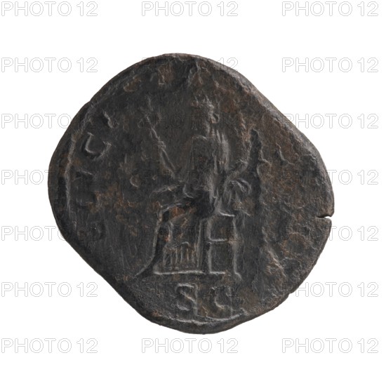 Sestertius depicting Julia Mamaea ca. 180–235 and Alexander Severus 208–235; Roman emperor 222–235. Obverse/legend references imperial titles and hierarchy of power. Reverse: personification Felicitas. Iconography associated with Julia Mamaea 180–235. Date: 222–235 CE. Place of creation: Rome, Roman Empire. Object: coin sestertius. Measurements: diameters 25.0 mm and 29.0 mm; weight 18.4 g., A round, slightly irregular dark object with a rough, textured surface showing worn raised areas and shallow depressions, predominantly black and dark brown with patches of reddish-brown; the central area features a faint, low-relief depiction of a seated humanlike figure holding a long, thin vertical object in one hand and a shorter object in the other, with indistinct surrounding shapes and a few shallow grooves near the lower edge.