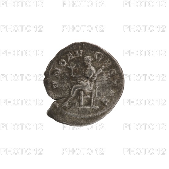 Denarius depicting Julia Mamaea ca. 180–235; Augusta 222–235 and Alexander Severus 208–235; Roman emperor 222–235. Obverse/issuer: Alexander Severus; reverse: Juno Roman deity. Iconography of Julia Mamaea 180–235. Date: 225–235. Place: Rome, Roman Empire 27 BC–476. Material: coin; diameter 18.5–19.0 mm; weight 2.75 g., A worn round coin with an uneven edge and a small chip, shown against a white background; the coin is primarily gray with darker gray and blackened areas and lighter silvery highlights, and it bears a faint raised image of a seated figure on a chair holding an object, with the surrounding surface showing worn raised markings and textured pitting.