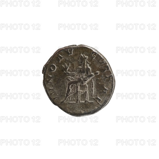 Denarius depicting Julia Mamaea ca. 180–235; Augusta 222–235 and Alexander Severus 208–235; Roman emperor 222–235; obverse/title inscriptions and imperial titles; reverse: Juno myth. — Roman deity; iconography of Julia Mamaea 180–235. Date: 225–235. Place: Rome, Roman Empire 27 BC–476. Medium: coin. Diameter: 18.5–19.5 mm. Weight: 3.32 g., A round coin with an irregular edge showing a raised central design of a seated figure holding an object, rendered in metallic tones of dark brown and bronze with lighter highlights and darker shadowed areas; the background around the coin is white.