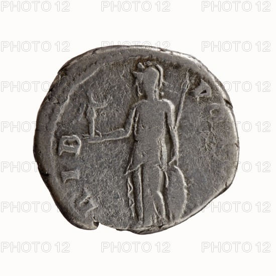 Denarius; obverse: head of Antoninus Pius without a cap to the right, legend IMP T AEL CAES - ANTONINVS; reverse: Minerva stands left, in her outstretched right hand she holds Victoria, in her lowered left hand she holds a spear with the head upwards and a shield resting on the ground, legend TRIB - POT COS; Roman, 138 CE; issuer: Hadrian as issuer / Antoninus Pius caesar 138; iconography: Minerva with Victoria, shields, spears; material: coin; diameter 16.0–17.0 mm; weight 3.06 g; axis 165°; Rome., A round, worn metal coin in shades of gray and dark silver shows a raised, low-relief figure of a standing person facing forward, with one arm extended and the other holding a long object; the figure appears to wear a short garment and headpiece. The coin surface is textured and slightly pitted with uneven edges and small chips, and there are faint raised shapes around the perimeter that suggest previous markings. The overall colors visible are gray, dark silver, and muted metallic tones.
