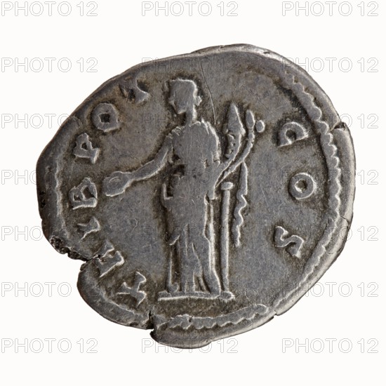 Denarius, Hadrian 76–138; Roman emperor 117–138 as issuer; Antoninus Pius 86–161; Roman emperor 138–161, caesar 138. Obverse: Head of Antoninus Pius bare, facing right, legend IMP T AEL CAES - ANTONINVS all around. Reverse: Concordia standing left; in her outstretched right hand a patera, in her left hand resting on a slender column a cornucopia; legend TRIB POT - COS all around. Iconography: Concordia, columns, personifications, cornucopias, paterae. Date: 138. Place of origin: Rome, Roman Empire. Object type: coin denarius. Measurements: diameter 17.0–18.0 mm, weight 3.30 g, axis 195°., The image shows a single round metallic object with a worn, uneven edge and a slightly irregular outline, primarily in shades of gray and silver with darker gray areas; the surface has a raised relief of a standing human figure in profile wearing a long garment, extending one arm outward, with a tall slender object and a curved element beside the figure; a decorative border runs near the rim and there...