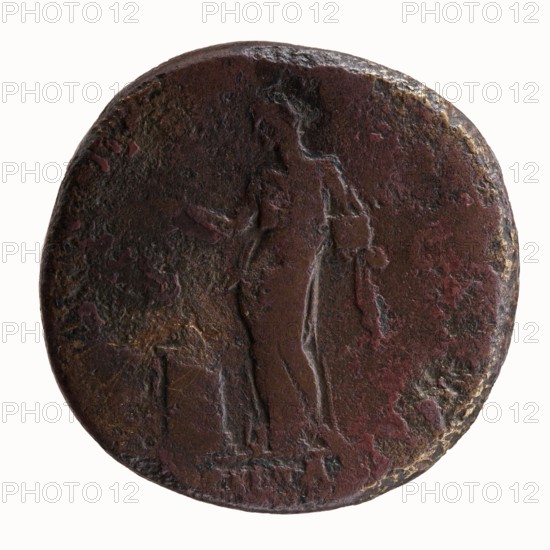 Sestertius of Antoninus Pius, 138 CE. Obverse: head of Antoninus Pius bare, facing right, legend IMP T AELIVS CAE - SAR ANTONINVS. Reverse: Pietas stands left before an altar, making an offering with his right hand and holding a container of perfumes in his left, legend TRIB POT COS DES II, episode PIETAS. Bronze coin sestertius, diameter 29.5–30.0 mm, weight 26.32 g, axis 180°., A round, worn metal disc with a textured, uneven surface showing a faint raised outline of a standing human figure and a nearby small raised rectangular object, the surface displaying a mix of dark brown, reddish-brown, and hints of black and muted gold tones with areas of rough patina and subtle surface pitting.